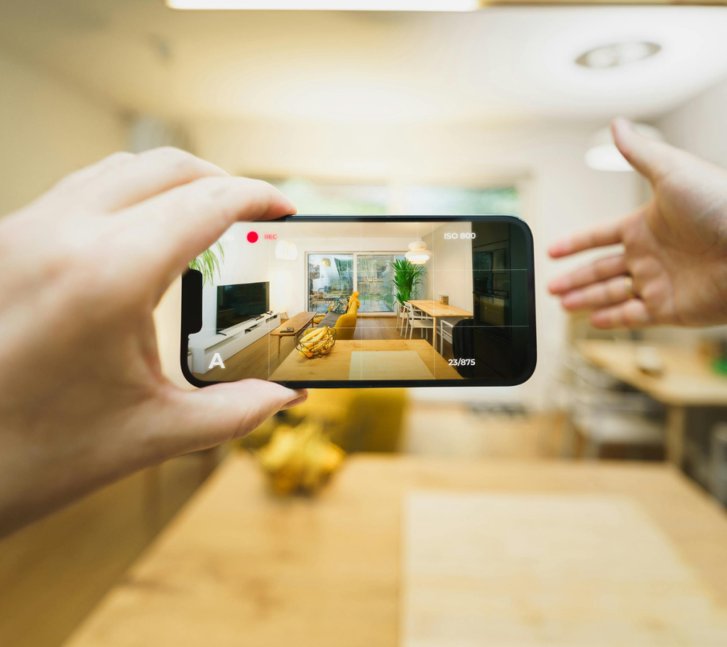 Person filming a home interior with a smartphone.