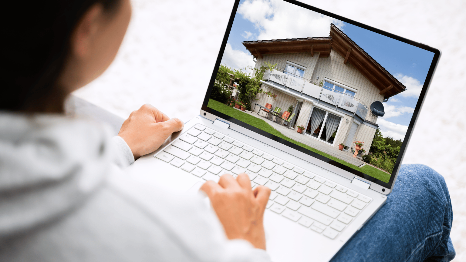 Person viewing real estate listings on a laptop to get their FSBO home on Realtor.com.