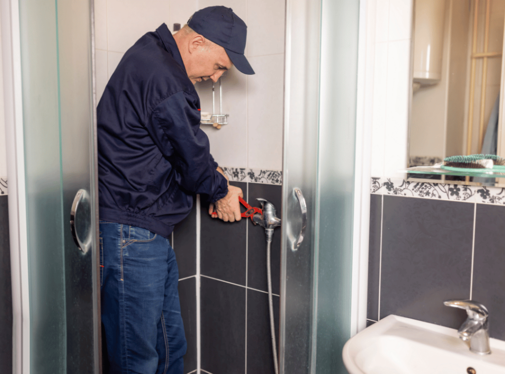 man checking faucet conditions in shower during home inspection