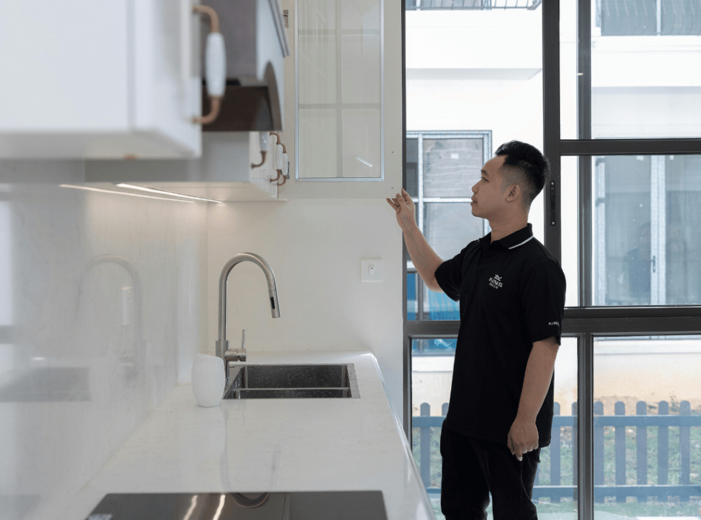 man checking kitchen cabinets during home inspection