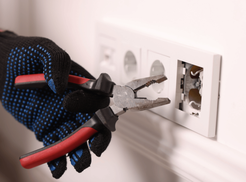 man checking the wires of the electrical outlet during home inspection