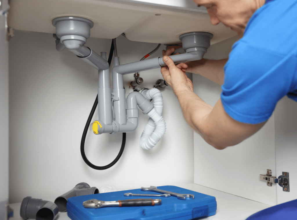 man inspecting plumbing in bathroom during home inspection
