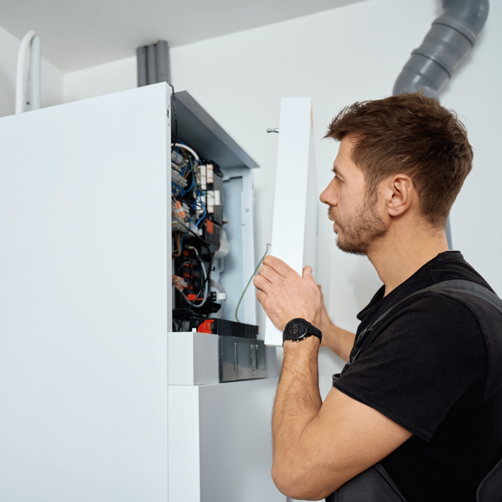 man inspecting electronic wiring in house inspection