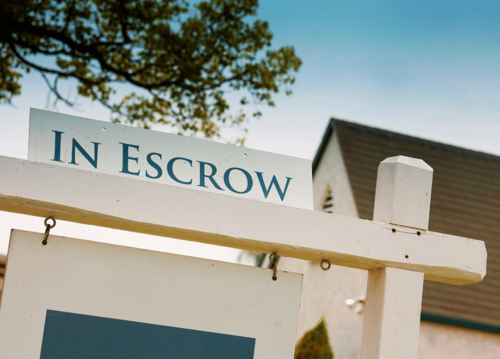 escrow flyer on top of home sale yard sign